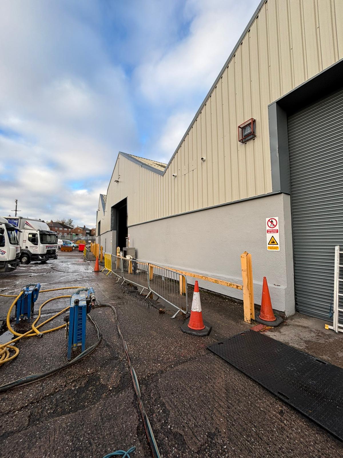 Warehouse exterior showing contaminated roller shutter before restoration
