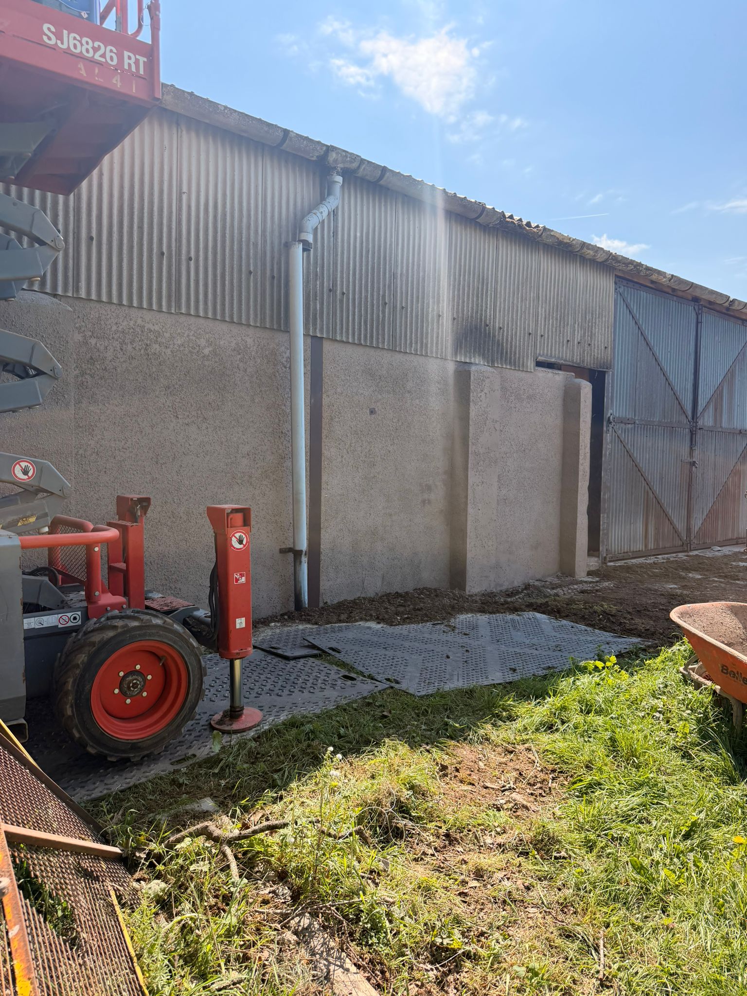Farm building concrete panels blasted clean with scissor lift on site