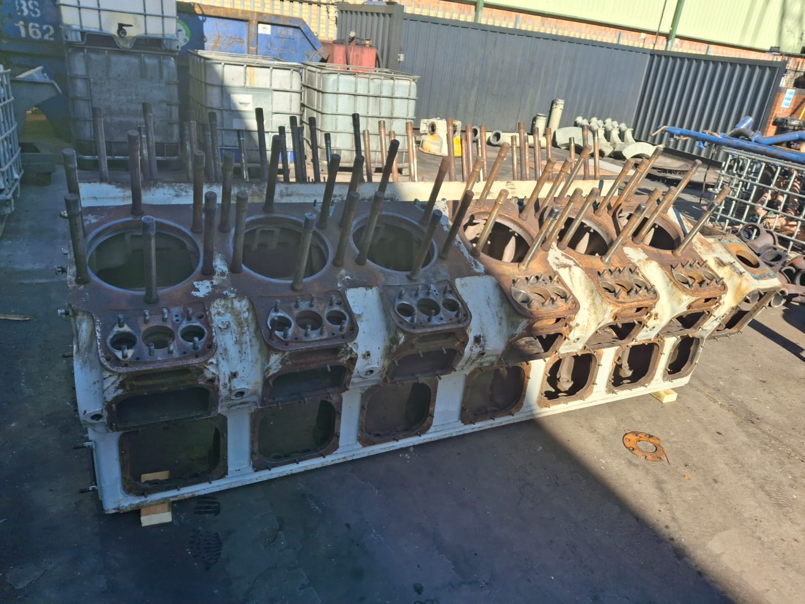 Marine engine block before shot blasting — side view showing corrosion and paint build-up